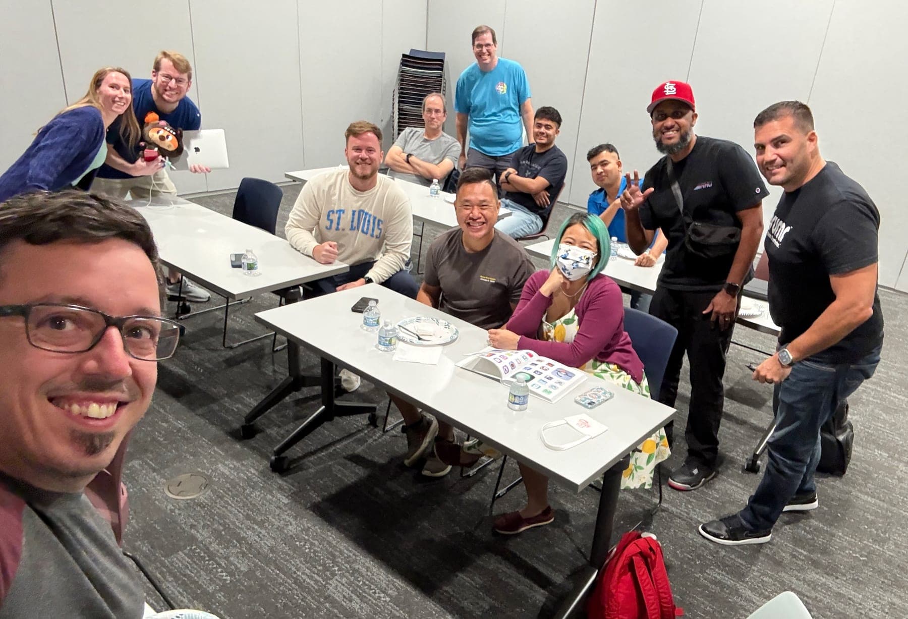 Small group gathered around tables at a St. Louis Shipaton 2025 meetup.